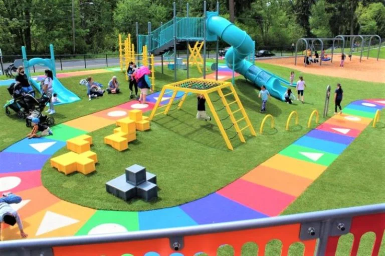 Vibrant outdoor play area with slides, swings, and colorful pathways.