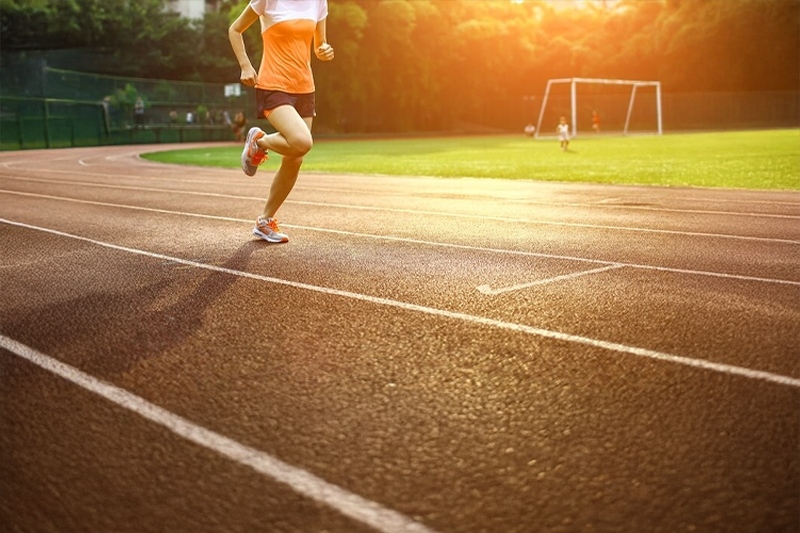Woman running on a sports track at sunset near Kohinoor Kaleido, Pune.